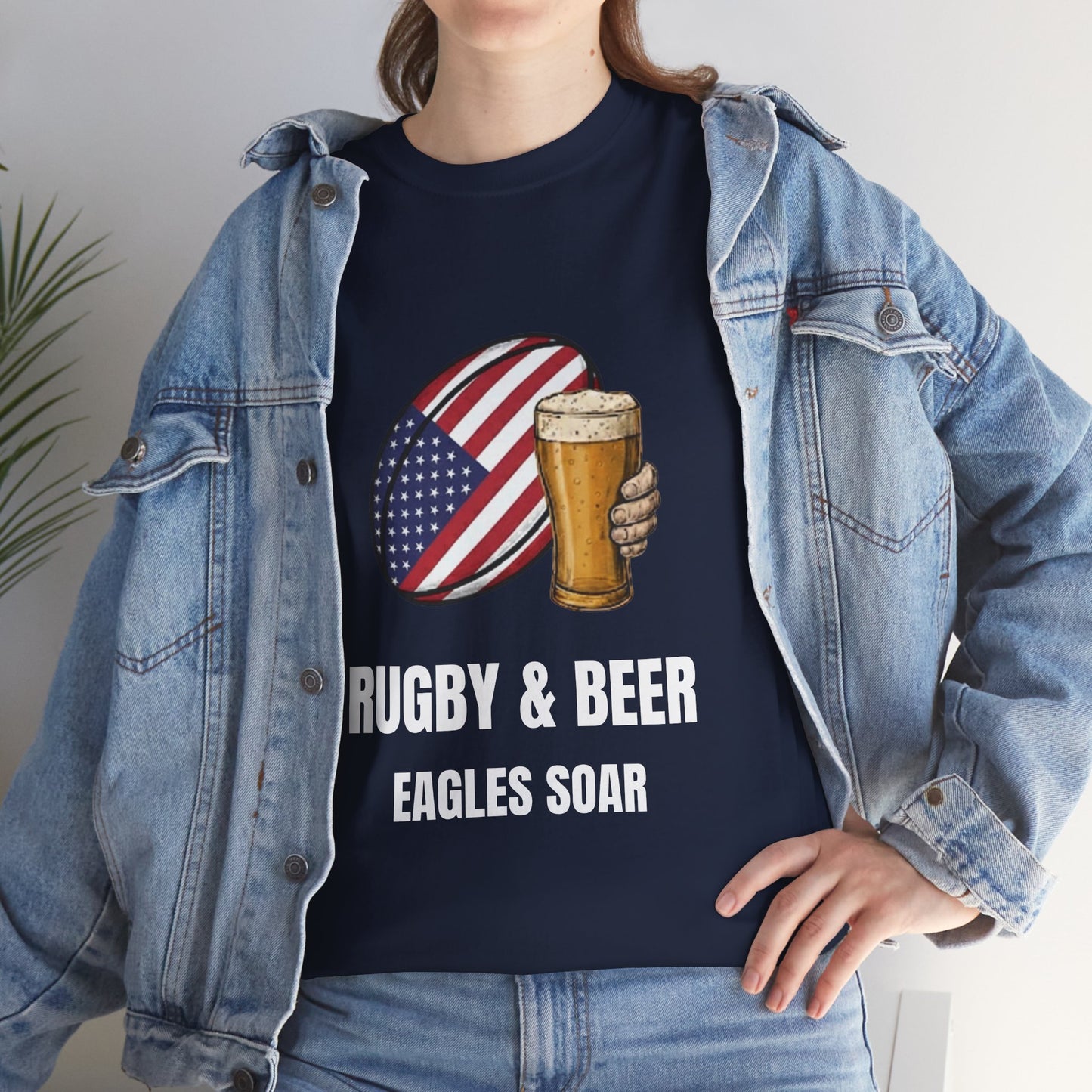 Lifestyle photo of a woman wearing Navy blue Eagles Soar t-shirt with rugby and beer graphic and text on a white background